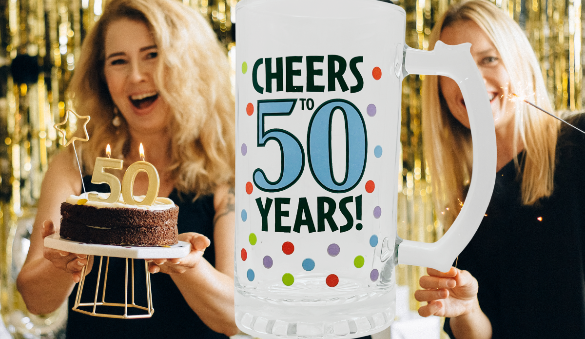 Cheers To 50 Years Beer Mug displayed at a 50th birthday party with gold decorations, birthday cake, and celebrating friends.