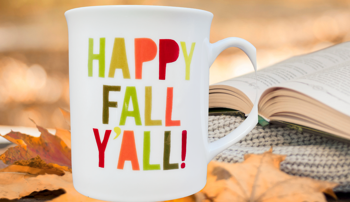 Happy Fall Y'all Mug displayed with autumn leaves, cozy knit texture, and an open book