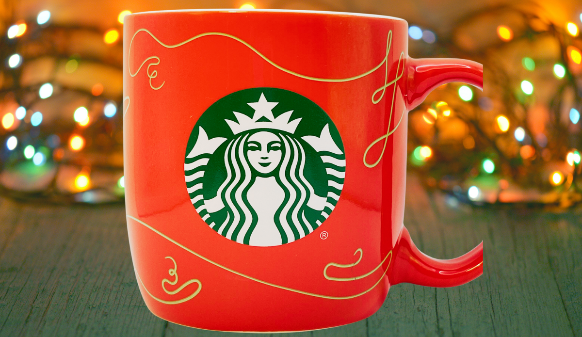 Starbucks 2020 Red Gold Swirl Holiday Mug displayed with glowing Christmas lights