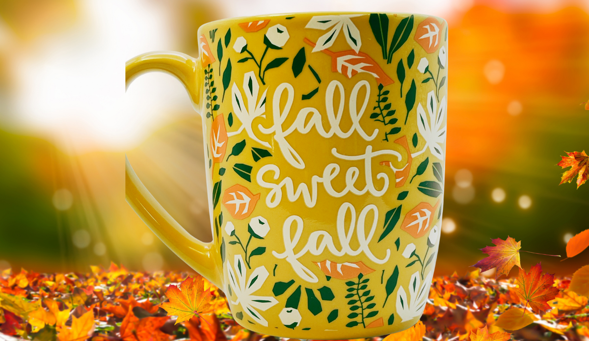 Fall Sweet Fall Mug displayed against a glowing autumn background with colorful fallen leaves