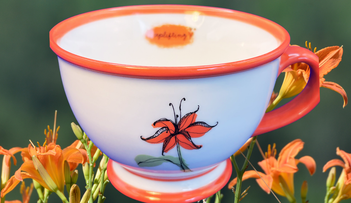 2006 Starbucks Tiger Lily Footed Teacup displayed with orange tiger lilies