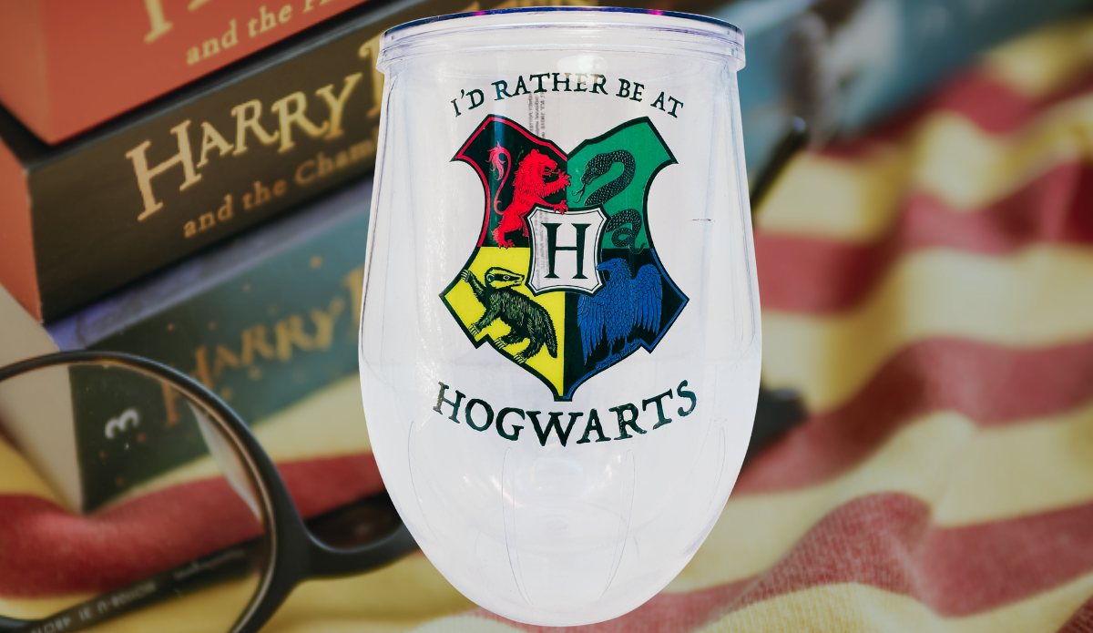 Harry Potter Hogwarts Stemless Travel Tumbler displayed with Harry Potter books, reading glasses, and a cozy blanket, creating a magical reading atmosphere.