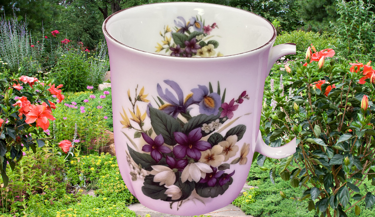 Springfield Purple White Floral mug displayed in a colorful garden setting