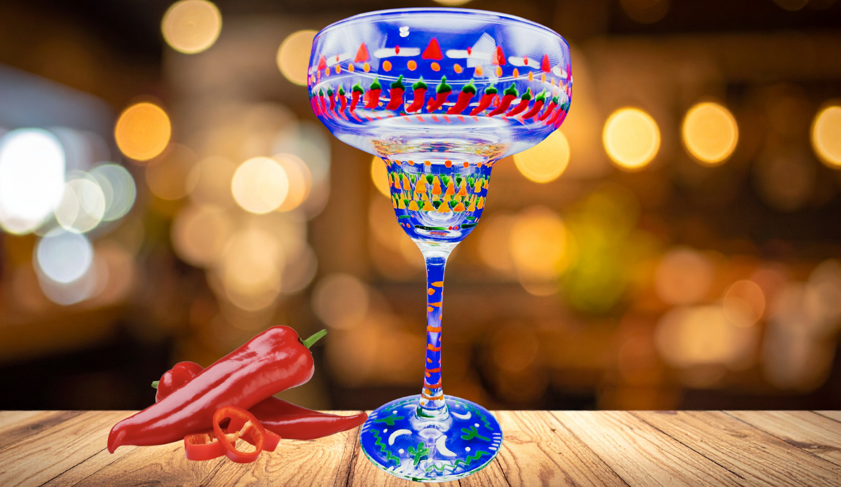 Southwestern chili peppers margarita glass on wooden table with warm lighting and fresh chili peppers
