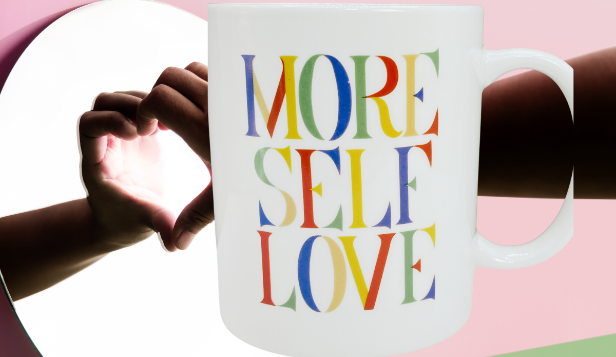 More Self Love Mug displayed beside a person forming a heart with their hands in a mirror