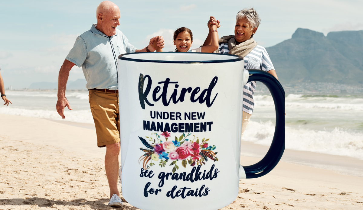 Retired Under New Management Grandkids Mug displayed with grandparents and grandchild on beach