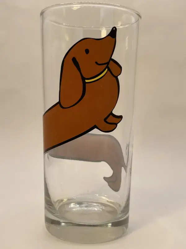 This 10-ounce clear glass features a captivating image of a brown dachshund that wraps seamlessly around the entire glass. Especially creating a fun and eye-catching design.