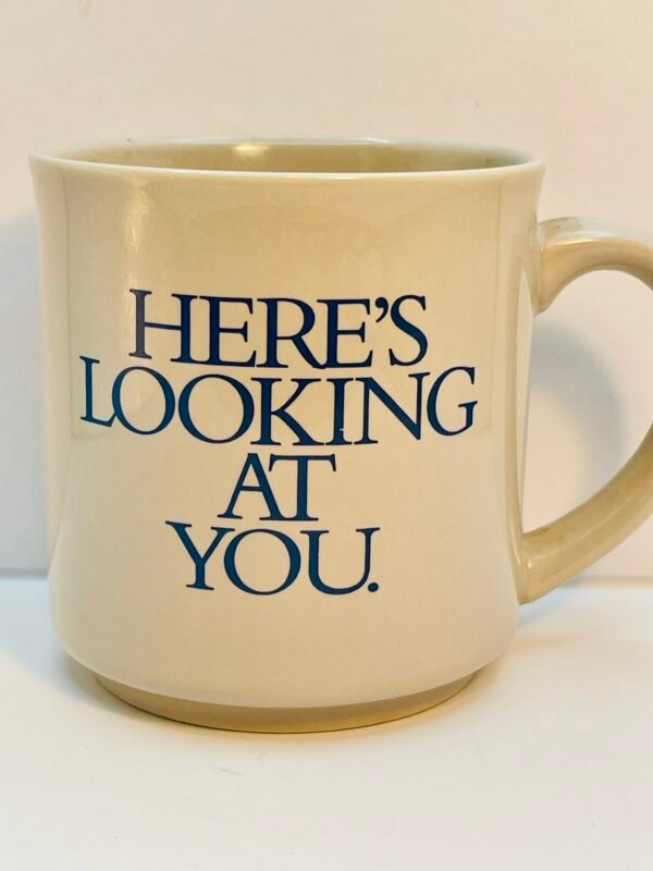Light gray Here’s Looking At You Mug with blue lettering on the outside