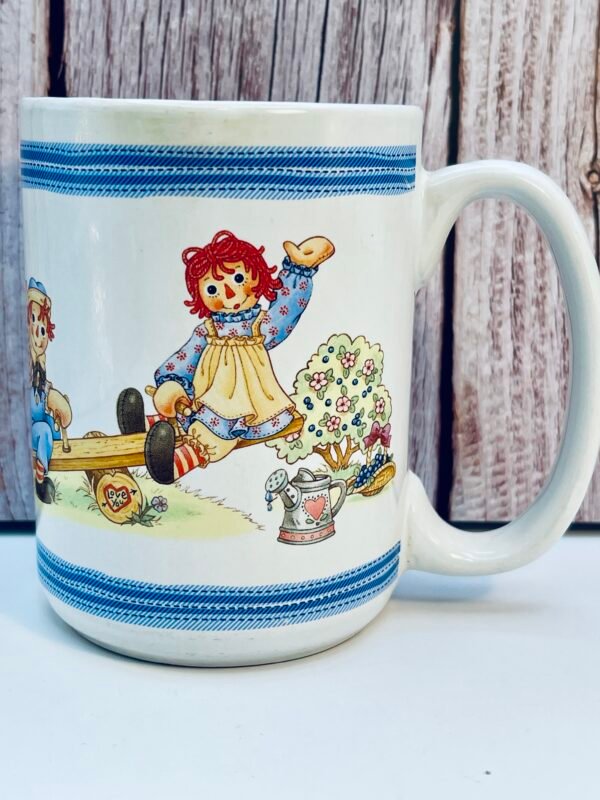 Raggedy Ann and Andy coffee mug on seesaw design