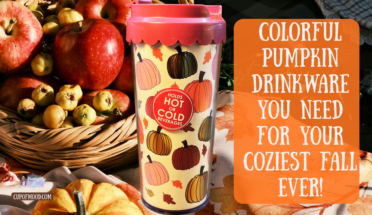Pumpkin coffee tumbler with lid covered in colorful pumpkins displayed beside apples and a fall harvest basket