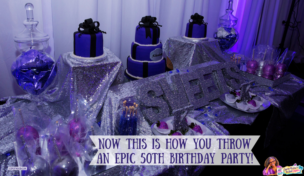 Purple and black birthday cakes arranged among silver glitter decorations, large sparkling letters, glass candy jars, and decorated desserts.