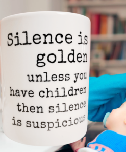 funny mom mug with silence is golden quote styled with mom holding baby and shushing gesture
