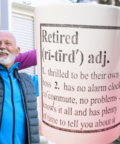 Retired Definition Funny Mug displayed with smiling retired couple outdoors