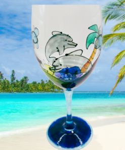 dolphins beach wine glass styled on tropical beach background with ocean and palm trees