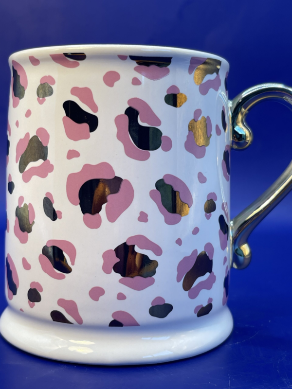 This 12-ounce white porcelain pedestal mug is the epitome of sophistication. Boasting a striking pink and gold leopard print that adds a dash of fierce glamour to your morning routine.