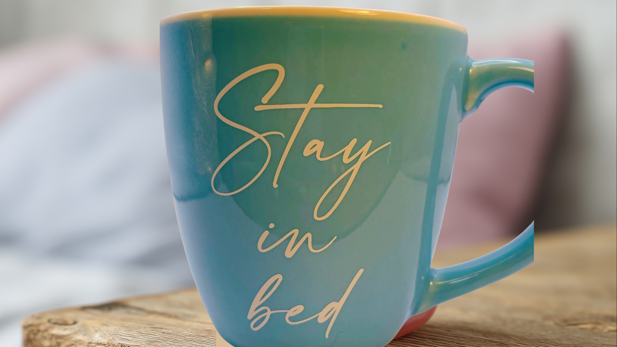 Stay In Bed Extra Large Mug lifestyle image on bed with cozy background