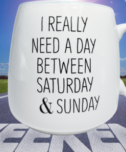 Need A Day Between Saturday And Sunday Mug displayed over weekend road scene with blue sky
