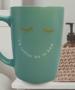 I’d Rather Be In Bed Mug styled on bedside table with soft linens