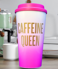 pink caffeine queen tumbler held in hand near coffee maker in kitchen setting