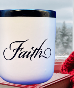Abbey Press Faith Script Mug on book by window with red knit blanket