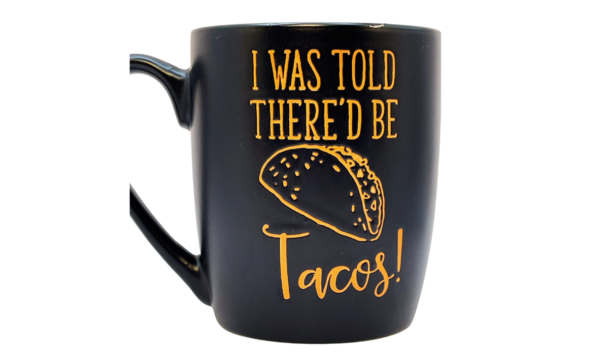 I Was Told There’d Be Tacos Mug front view with bright orange lettering and taco artwork on matte black ceramic