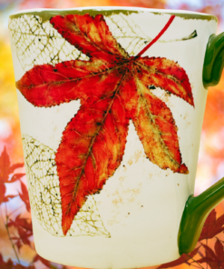 Pier 1 Asheville Fall Leaves Coffee Mug displayed against glowing red and orange autumn foliage