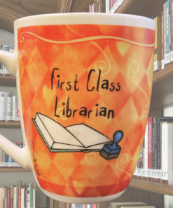 First Class Librarian Funny Mug styled on desk with books