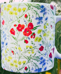 Ralph Lauren Wildflower Mug styled outdoors with wildflowers and greenery in a bright natural setting