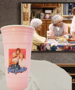 golden girls pink tumbler styled with cozy tv watching setup and blanket