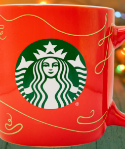 Starbucks 2020 Red Gold Swirl Holiday Mug displayed with glowing Christmas lights