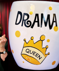 Drama Queen Mug in theatrical scene with red curtains and expressive woman