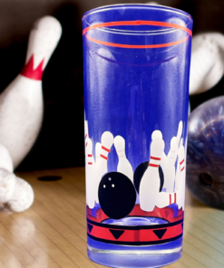 Vintage Bowling Drinking Glass displayed on bowling lane beside scattered pins and blue marbled bowling ball