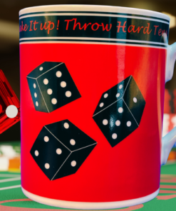 Godinger Craps Dice Coffee Mug displayed on a green casino gaming table beside a translucent red die and colorful gaming chips.