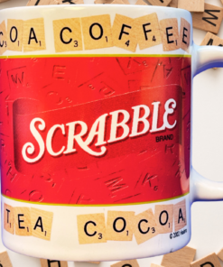 Scrabble Coffee Tea Cocoa Mug displayed among scattered wooden alphabet tiles on a light tabletop in a word-game-inspired setting.