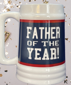 Father Of The Year Beer Stein Mug displayed beside a trophy and celebration décor