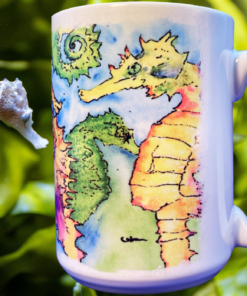 Swimming Seahorses Mug displayed in underwater inspired setting with realistic seahorse and green sea grass