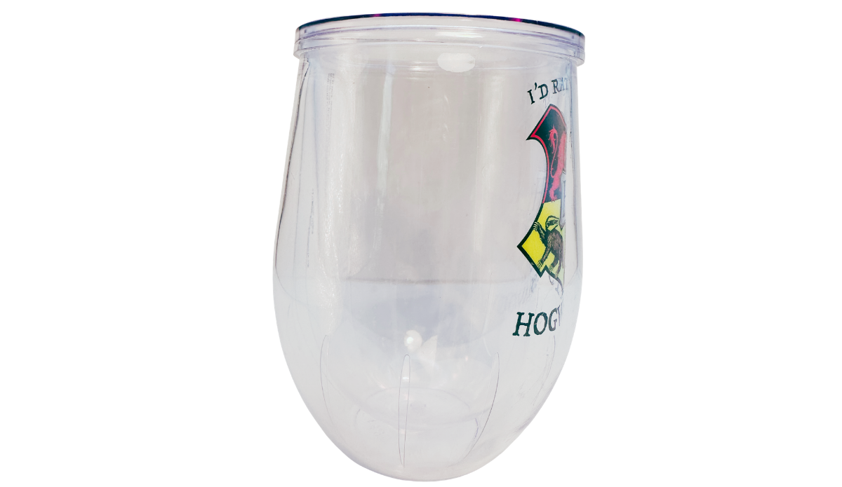 Harry Potter Hogwarts Stemless Travel Tumbler right side view showing the clear double-wall acrylic body with the edge of the colorful Hogwarts crest wrapping around the front.