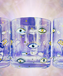 Multiple views of the Embellished Hamsa Hand Mug displayed in a glowing celestial setting