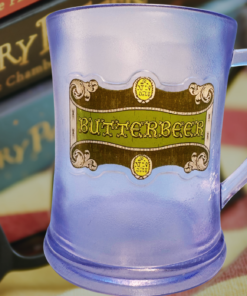 Harry Potter Frosted Butterbeer Souvenir Mug displayed with Harry Potter books, reading glasses, and a cozy blanket