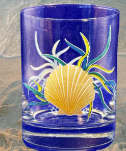 Coastal Scallop Shell Double Old Fashioned Glass displayed on sandy beach beside gentle ocean waves