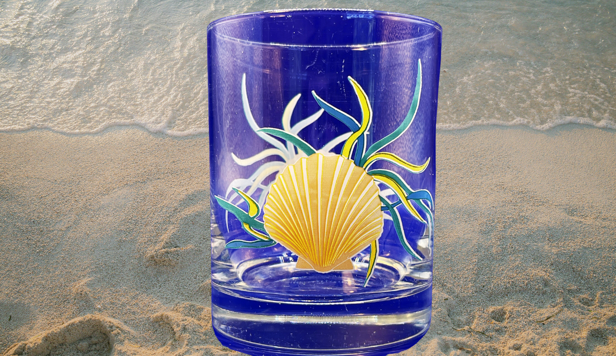 Coastal Scallop Shell Double Old Fashioned Glass displayed on sandy beach beside gentle ocean waves