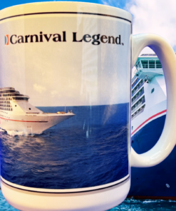 Carnival Legend Cruise Ship Souvenir Mug displayed in front of the Carnival Legend cruise ship at sea