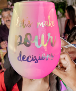 Pour decisions wine glass in party setting with friends holding drinks