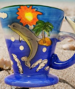 3D dolphin mug styled on beach sand with seashells creating tropical coastal drinkware vibe
