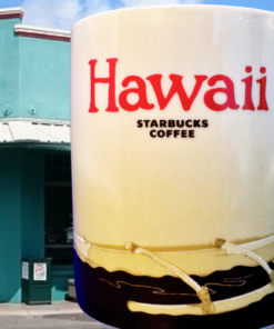 Starbucks Hawaii Outrigger Canoe Collector Mug displayed outside Starbucks Mānoa Valley in Honolulu, Hawaii, with its turquoise storefront and 1930 building detail.