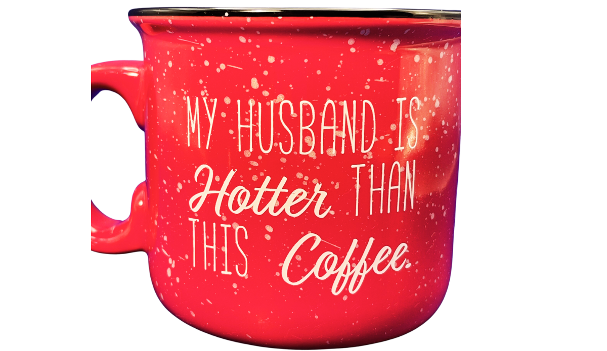 My Husband Is Hotter Than This Coffee Mug back view with repeated cream quote, red speckled glaze, dark rim, and left-side handle