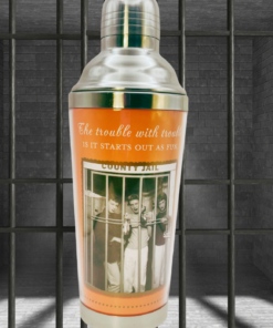 Shannon Martin Trouble Starts Cocktail Shaker displayed against jail bars and gray brick walls