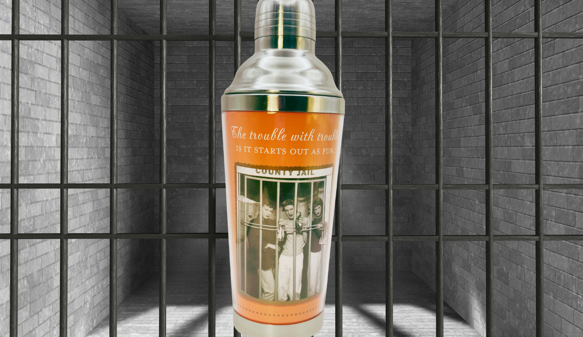 Shannon Martin Trouble Starts Cocktail Shaker displayed against jail bars and gray brick walls