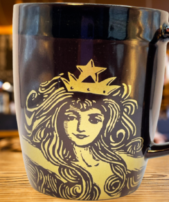 2012 Starbucks Anniversary Siren Mug displayed on cafe table with crowned Siren artwork