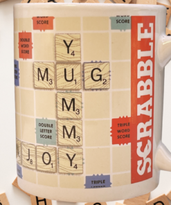 Scrabble Coffee Time Mug displayed among scattered wooden alphabet tiles, featuring MUG and YUMMY on a cream game-board design.
